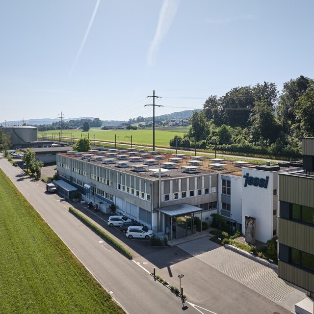 Aerial view of the Jossi company headquarters featuring production and office facilities in a rural setting. The image showcases the company’s location and the modern infrastructure of the industrial automation specialist.