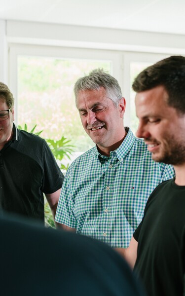 Several Jossi employees engage in an informal discussion. The scene conveys teamwork, collaboration, and open communication within the company.