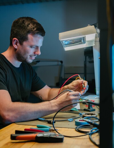Blick in die Fertigung von Jossi mit modernen CNC-Bearbeitungszentren und Mitarbeitenden an verschiedenen Arbeitsplätzen. Die Szene zeigt die präzise Herstellung und Bearbeitung von Komponenten für industrielle Automatisierungslösungen.